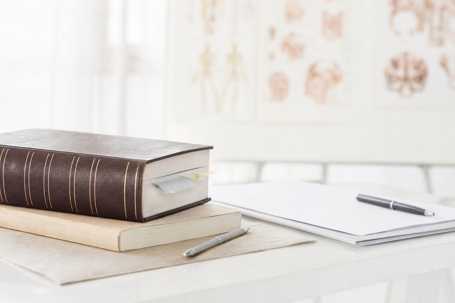 Un uomo seduto legge con attenzione un libro aperto tenuto fra le mani.